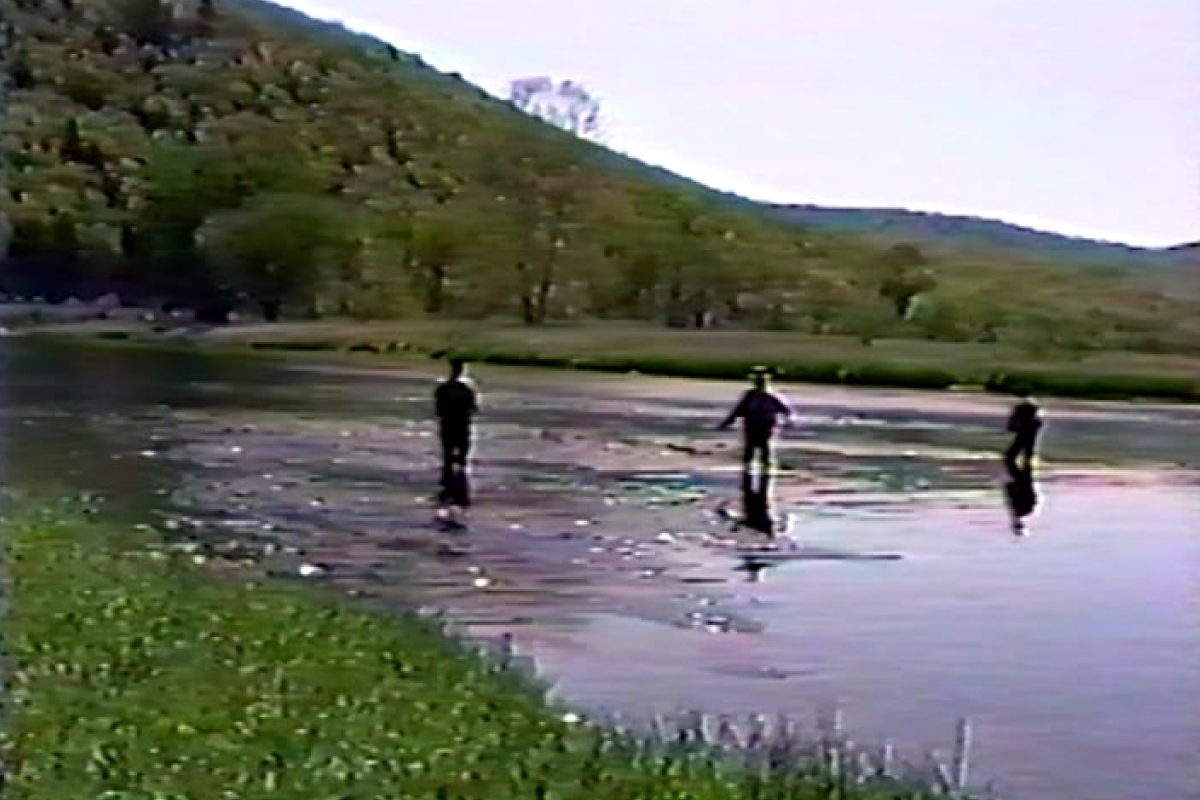 A video screenshot of three anglers standing in a shallow stream.